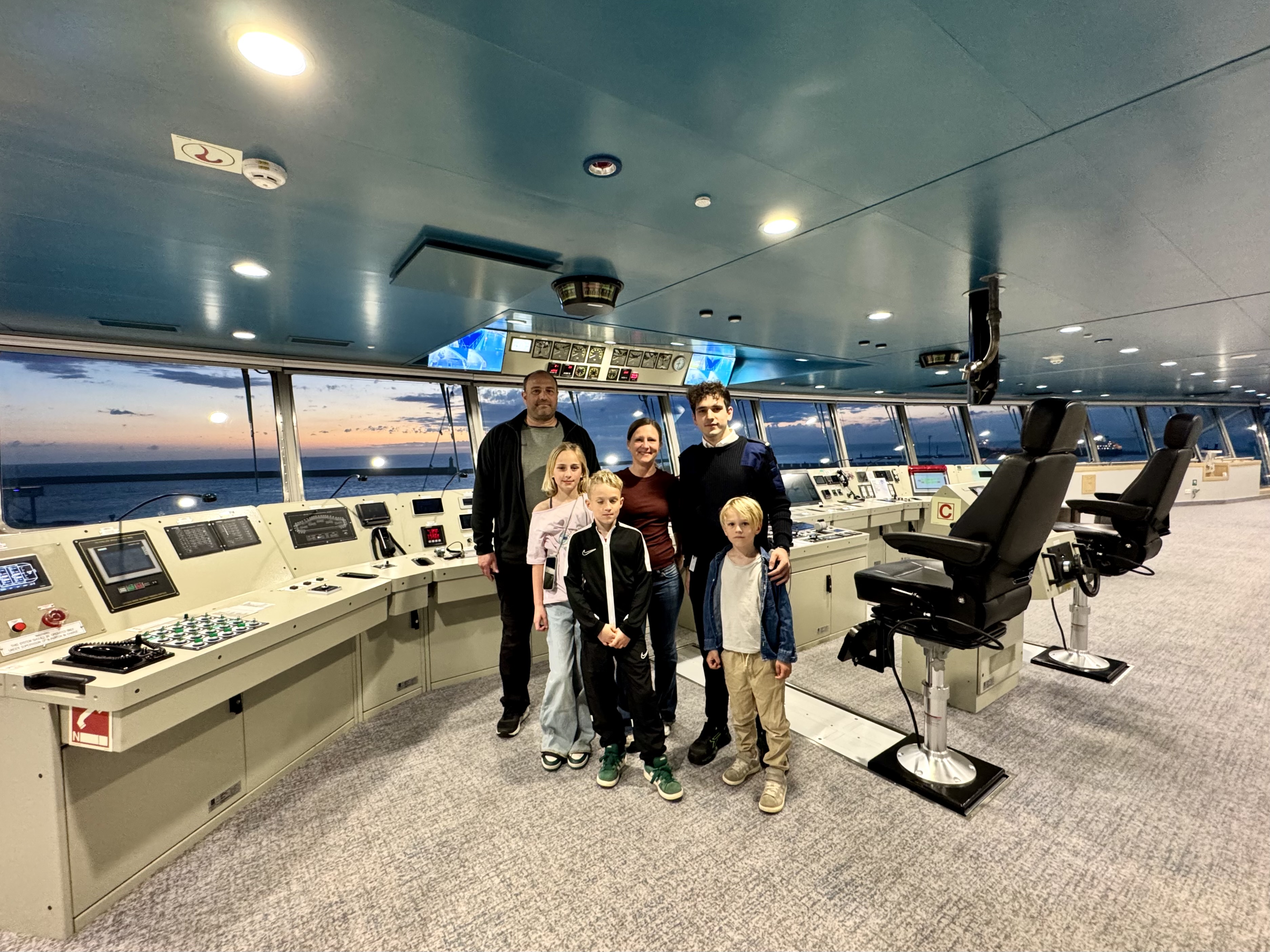 Mit der Fähre nach Sardinien: Bei unserer letzten Überfahrt durften wir uns die Brücke der Moby Legacy ansehen. Man sieht eine fünfköpfige Familie mit einem der Offiziere an den Steuergeräten stehen.
