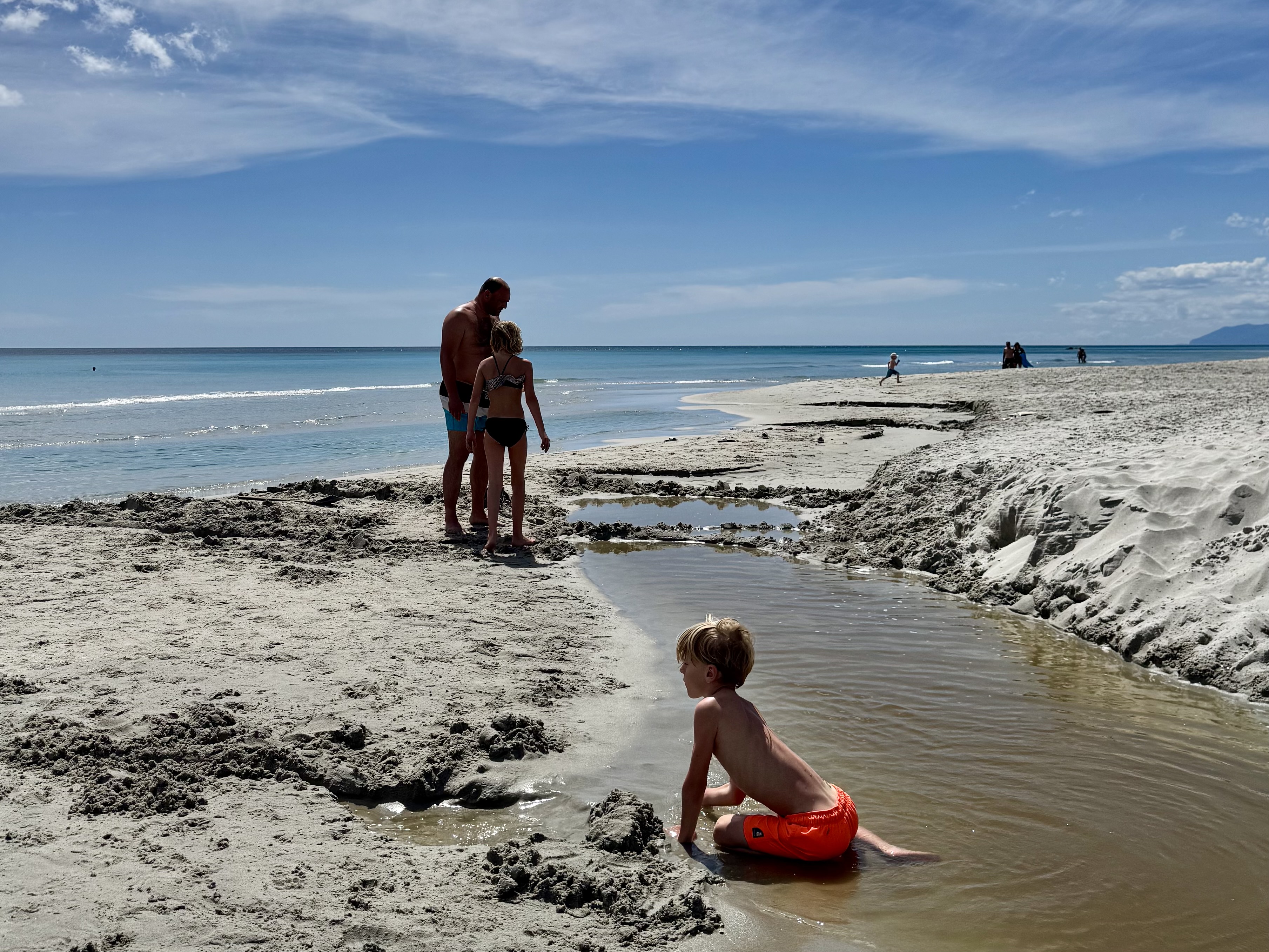 Where to go in Italy with kids: children are playing on the beach