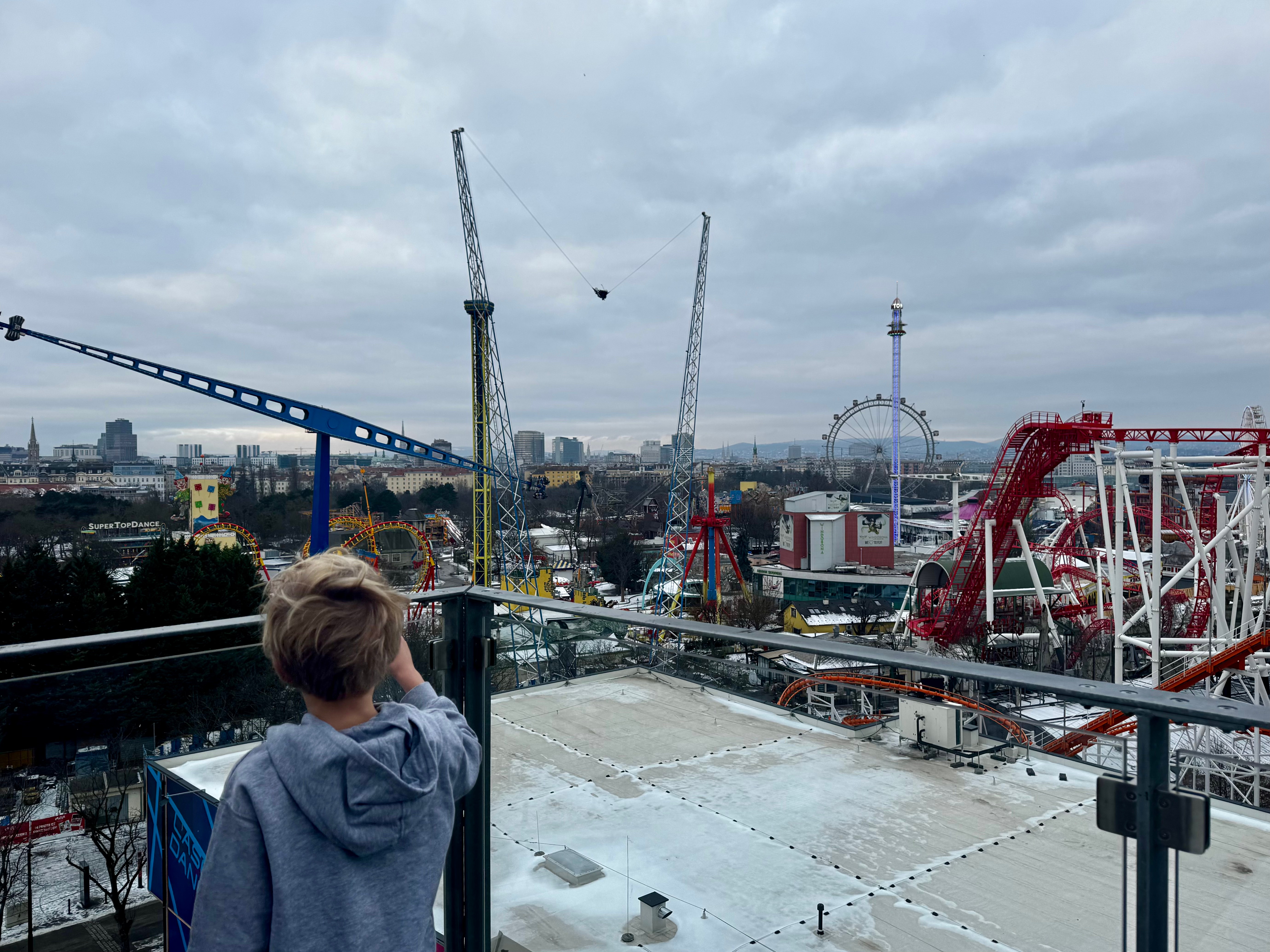 The best things to do in Vienna with kids - a boy is standing outside and having a view of the Vienna Prater from Superbude Hotel.