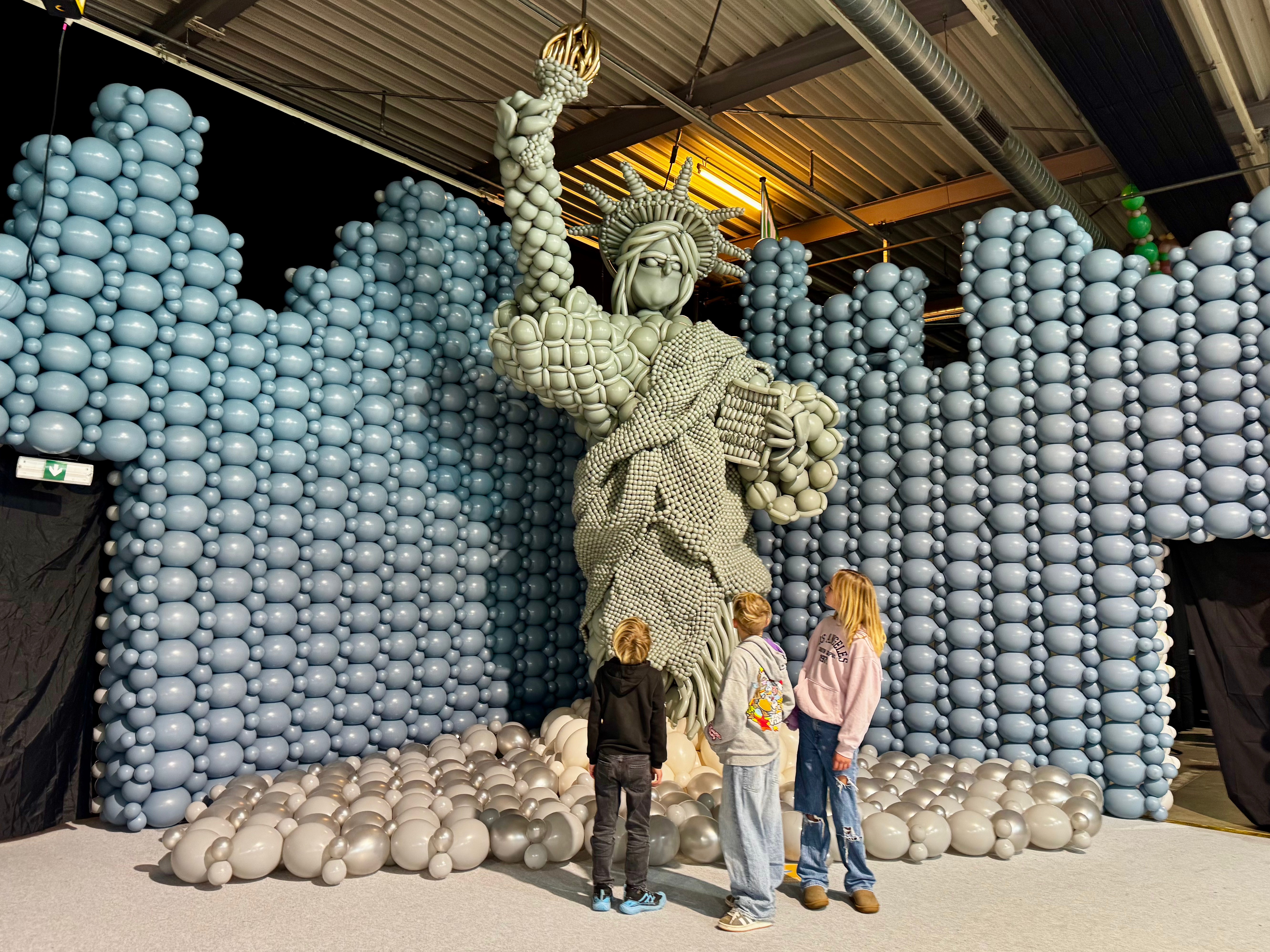 Luftballonwelten München: 3 Kinder vor der Freiheitsstatue aus Luftballons, Bereich Nordamerika