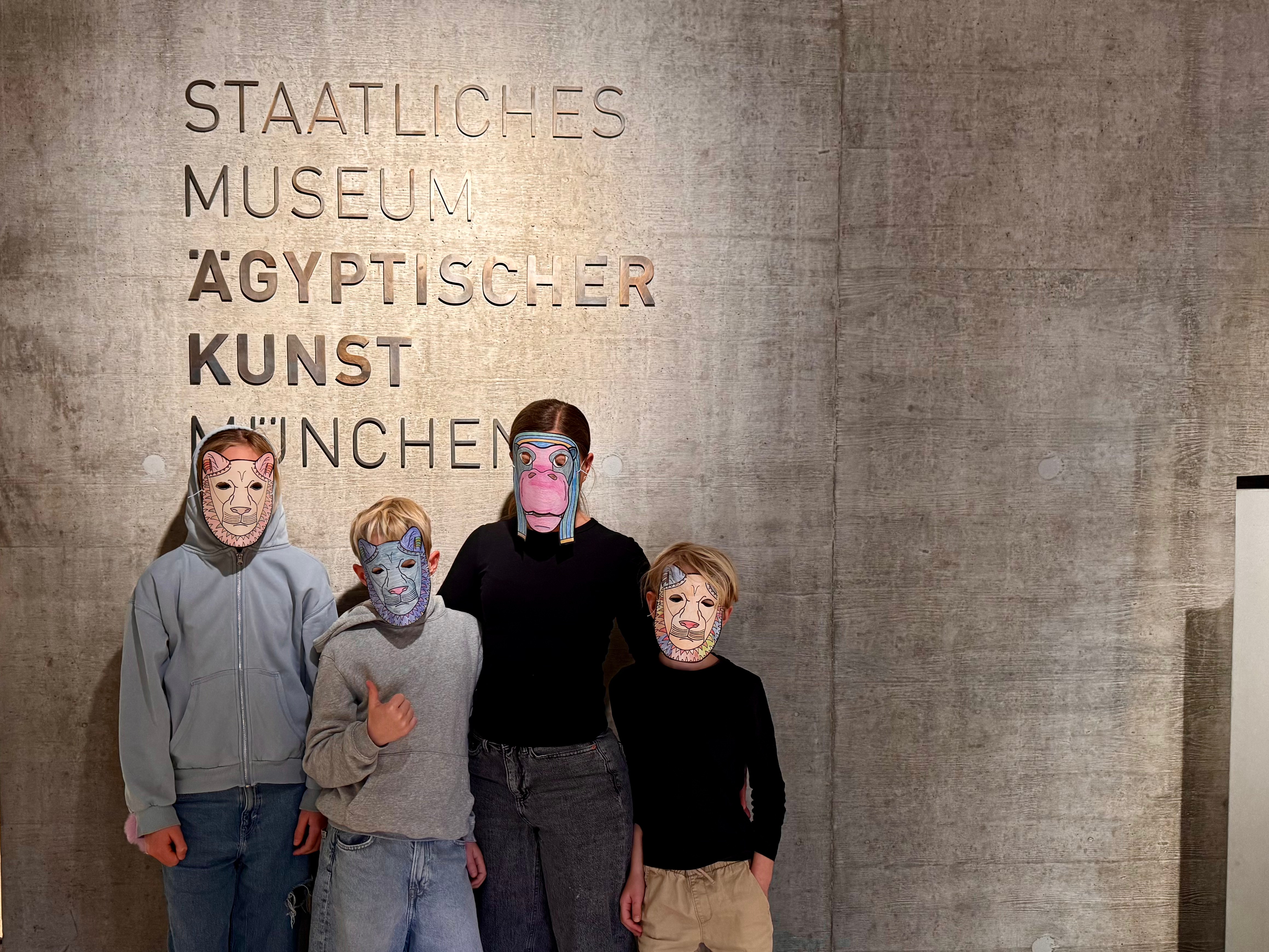 Ägyptisches Museum München mit Kindern: Eine vierköpfige Familie mit Tiermasken nach der Führung "In Tiergestalt"
